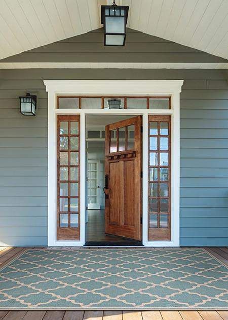 the front door of a house with two lights on each side and an entry way