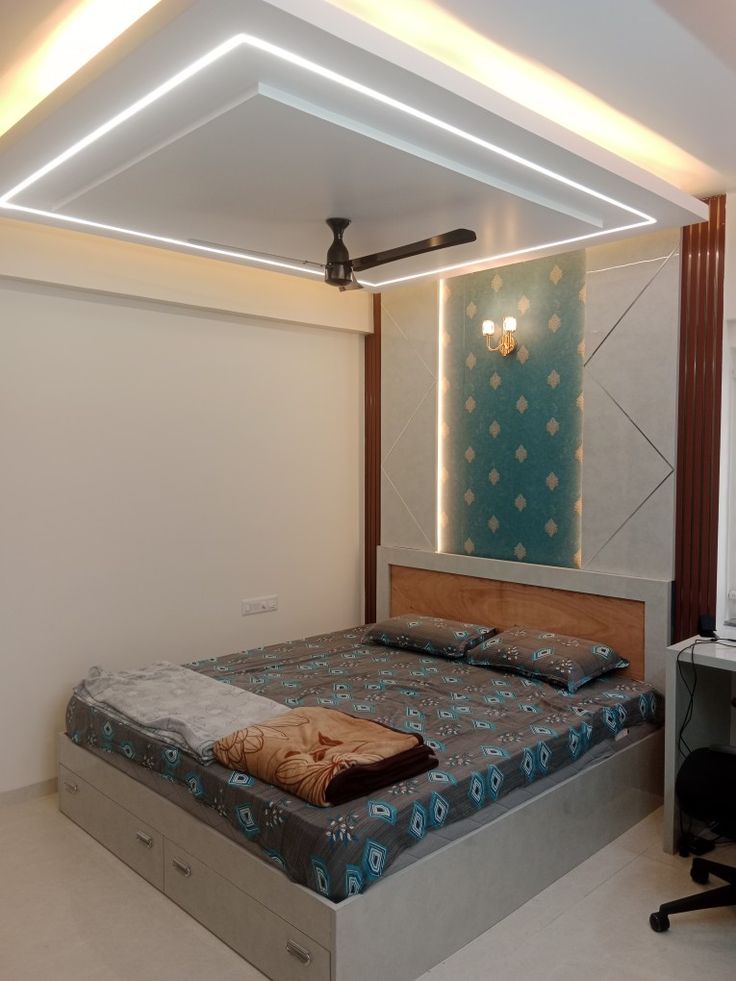 a bed sitting in the middle of a room under a ceiling light with lights on it