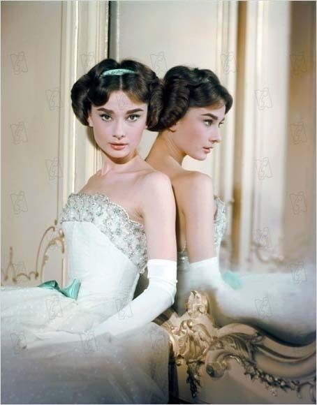 two young women in white dresses are posing for a photo together, one is wearing a tiara and the other has a green ribbon on her headband