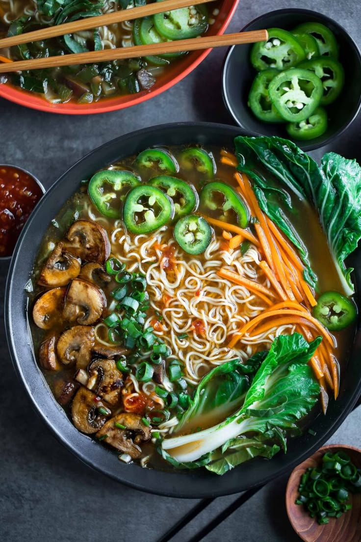 an overhead view of a bowl of noodle soup with chopsticks on the side