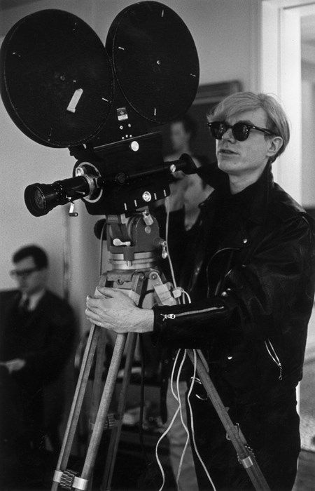 an old black and white photo of a man holding a camera in front of him