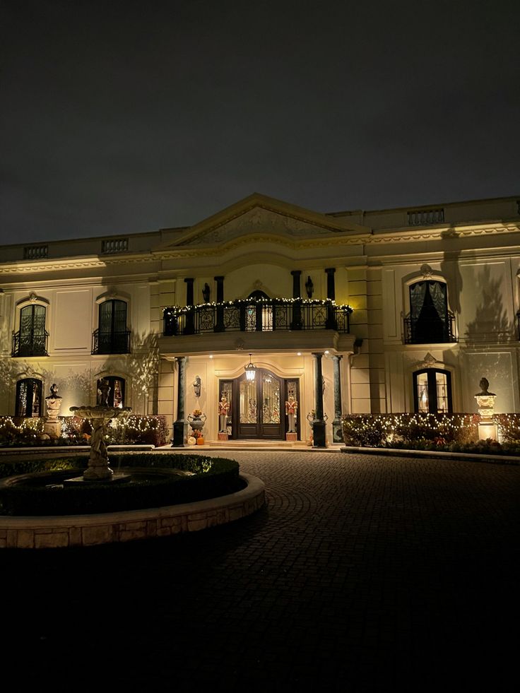 a large building lit up at night with lights on it's windows and balconies