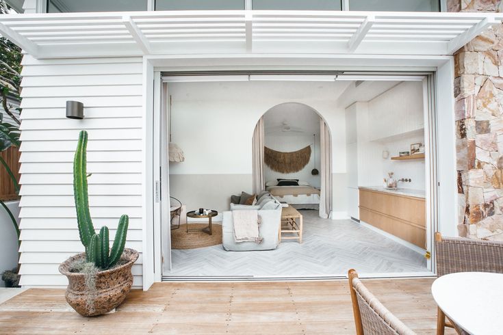 an open door leading to a living room and dining area with a cactus in the corner