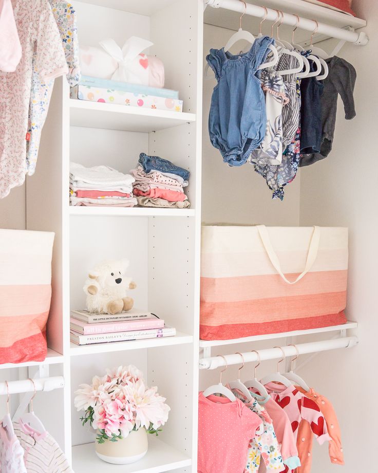 an organized closet with baby clothes and toys