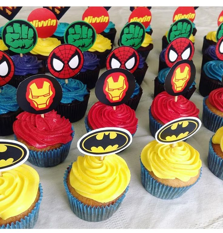 many cupcakes are decorated with colorful icing and spider - man faces on them