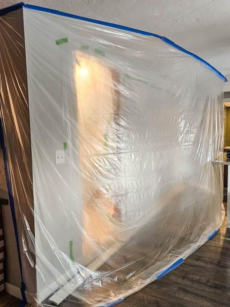 a room that is covered with plastic in the process of being painted and decorated for painting