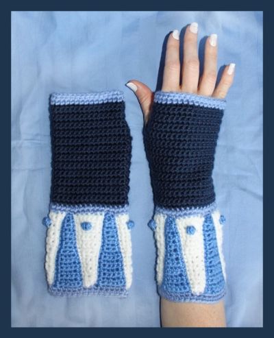 a woman's hand wearing blue and white crocheted gloves