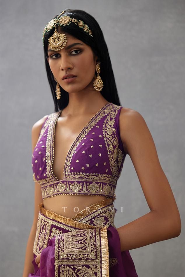 Violet sleeveless blouse with dori, sequin embroidery in floral pattern.
Components: 1
Pattern: Embroidery
Type Of Work: Dori, sequin, floral
Neckline: Plunge V neck
Sleeve Type: Sleeveless
Fabric: Handwoven Chanderi
Color: Purple
Other Details: 
Back tassel tie-up
Note: Saree worn by the model is not for sale
Occasion: Wedding - Aza Fashions V-neck Wedding Sets With Sequins, V-neck Sequin Wedding Set, Elegant Sleeveless Set With Intricate Embroidery, Elegant Sleeveless Sets With Intricate Embroidery, Evening Lehenga With Resham Embroidery, Festive V-neck Sequin Sets, Sleeveless Lehenga With Intricate Embroidery For Party, Party Lehenga With Intricate Embroidery And Sleeveless Design, Sleeveless Resham Embroidery Party Wear Sets