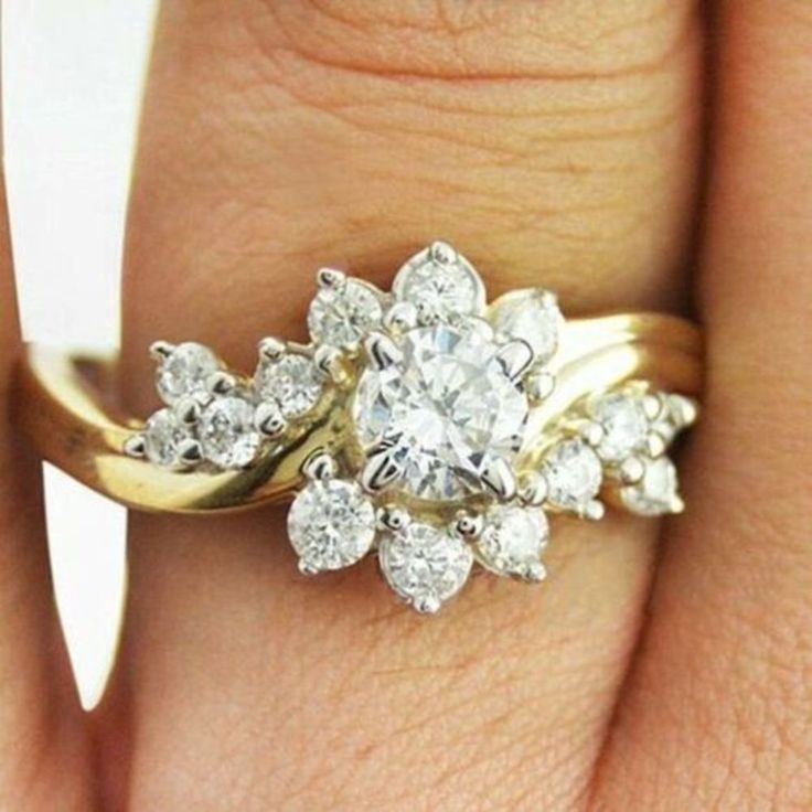 a woman's hand with a gold and diamond ring on top of her finger