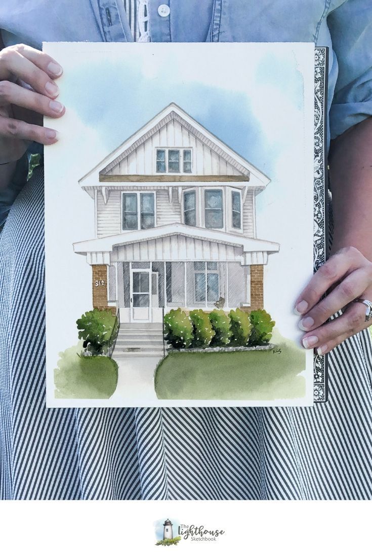 a person holding up a drawing of a house