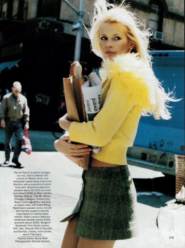 a woman in a yellow sweater and green skirt