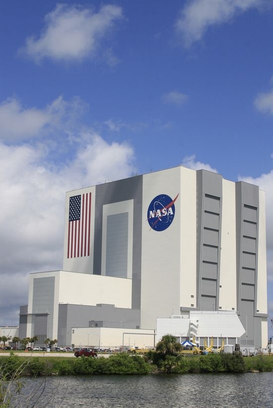 an image of the space shuttle building from across the water