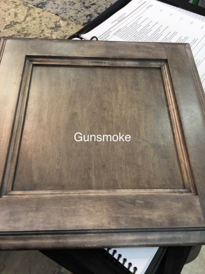 the words gunsmoke are written in white ink on a wooden frame next to some papers