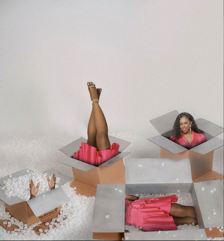 a woman laying in some cardboard boxes on top of white foam covered ground with her legs sticking out