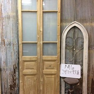 an old chair sitting in front of two wooden doors