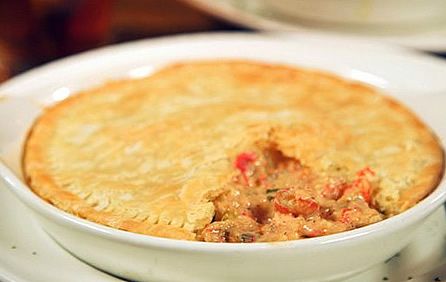 a close up of a pie in a bowl on a plate with other plates and utensils