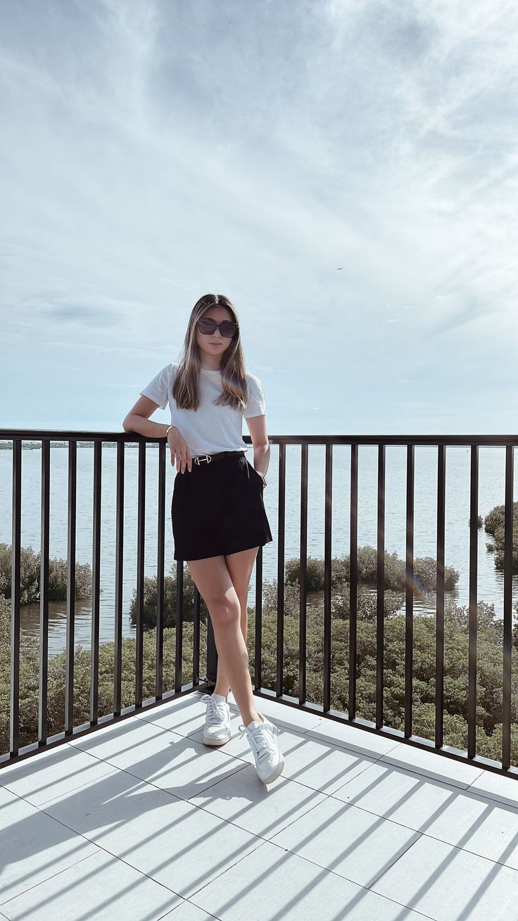 Tampa based fashion influencer Lauren Lora wearing a smart casual summer outfit. She’s wearing a white t shirt, black tailored shorts and white sneakers. Casual Skirts And Tops, Veja And Dress Outfit, White T Shirt And Shorts Outfit, White Sneakers Outfit Classy, Veja Sneakers Outfit Shorts, Skirt Shorts Outfit Classy, White T Shirt Outfit Summer, Black Shorts White Shirt Outfit, White T Shirt Black Skirt