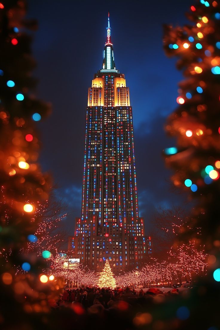 the empire building is lit up at night with christmas lights on it's sides