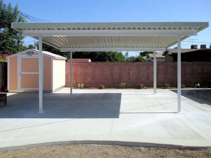 a white pergoline sitting on top of a cement lot