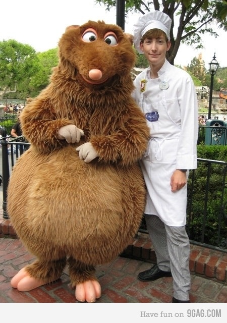 a man in a chef's outfit standing next to a giant stuffed animal character