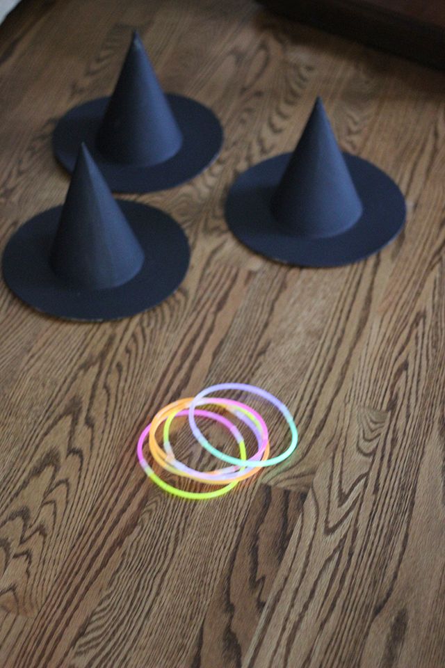 several black hats are sitting on the floor next to some colored circles and rings in front of them