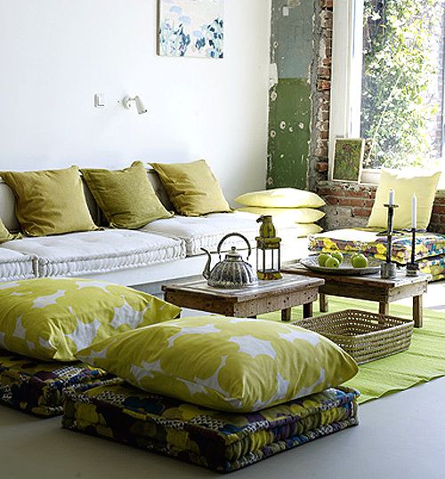 a living room filled with lots of furniture and pillows on top of it's floor