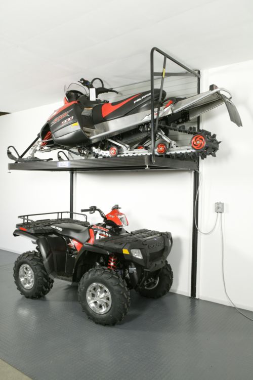 a four wheeler is parked on top of a shelf with a snowmobile attached to it