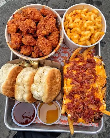 a tray filled with different types of food on top of a table next to macaroni and cheese