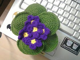 a crocheted flower sitting on top of a computer keyboard