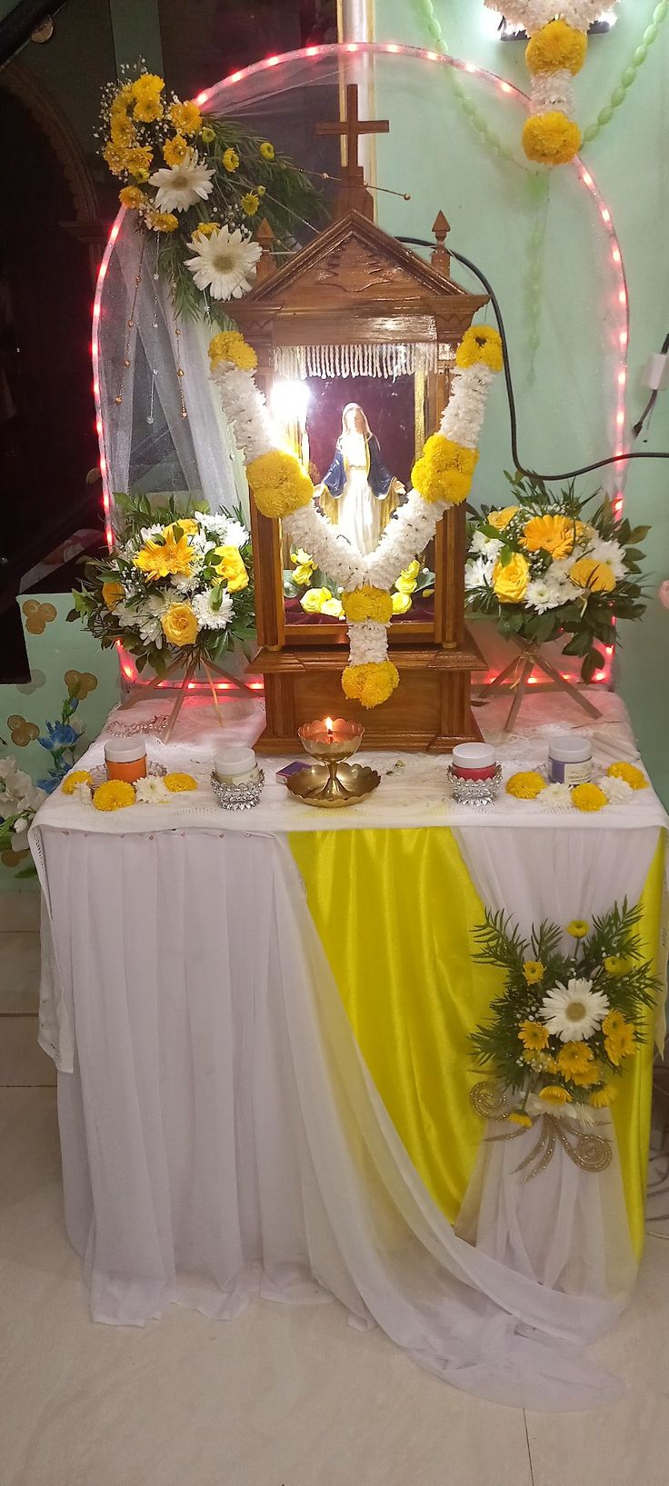 the altar is decorated with yellow and white flowers