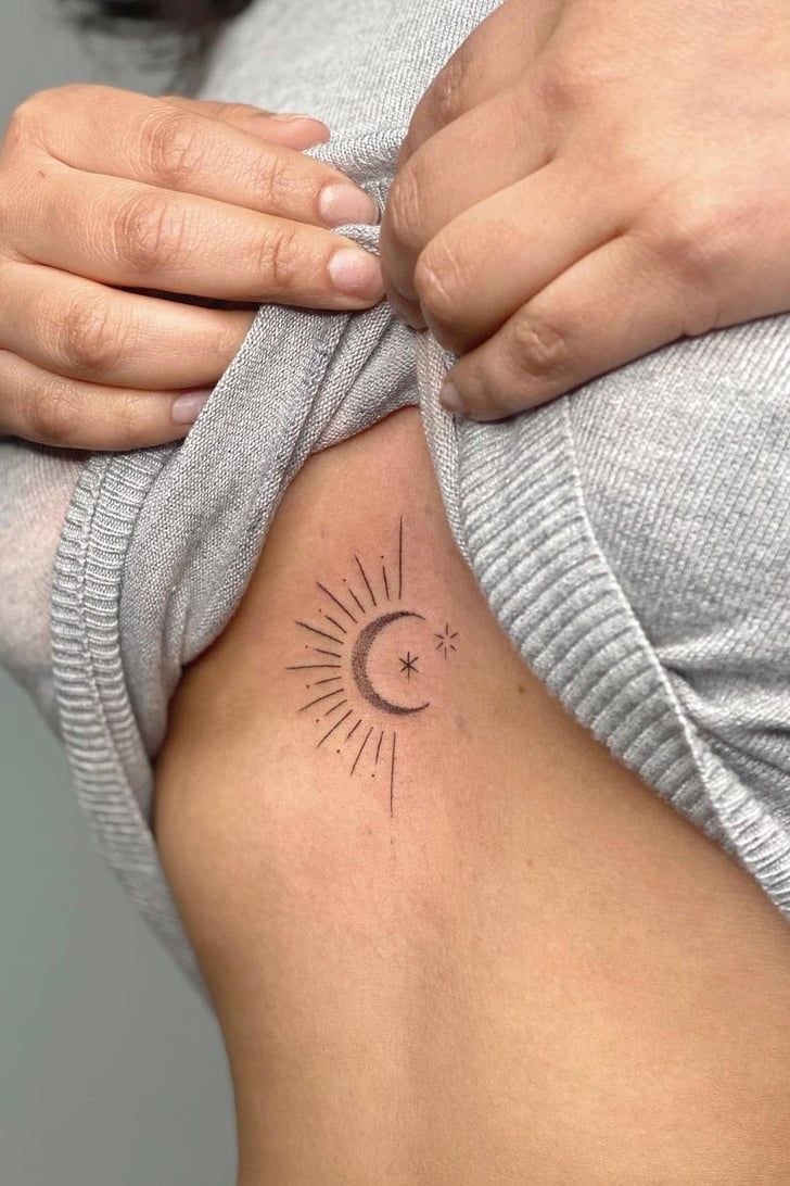 a woman with a small sun and moon tattoo on her lower back ribcage