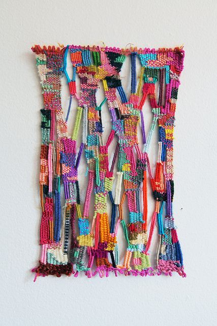 a multicolored wall hanging made out of beads