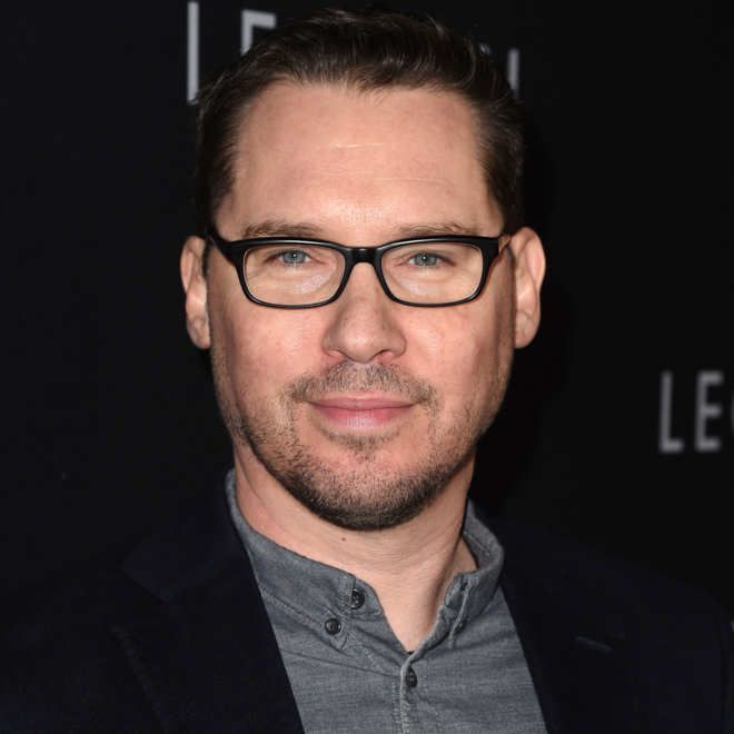 a close up of a person wearing glasses on a red carpeted area with a black background