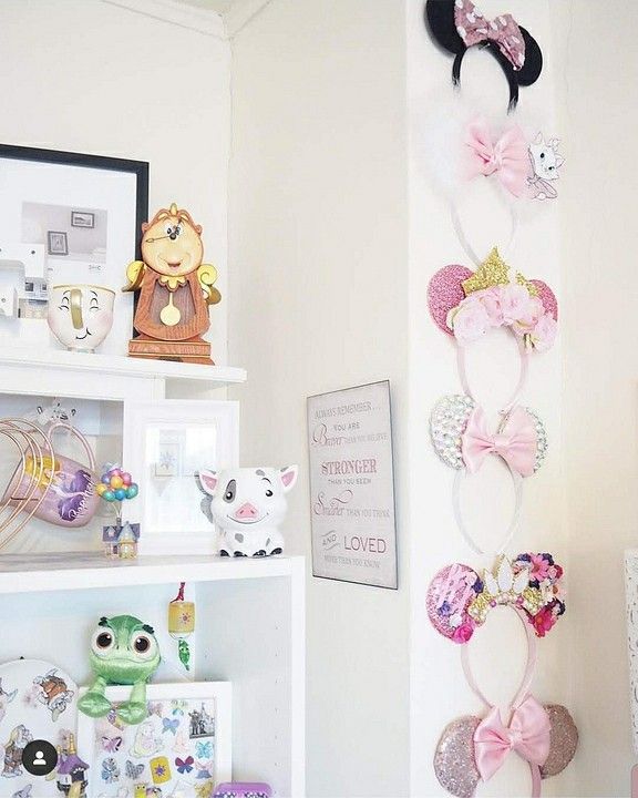 there are many disney mouse ears hanging on the wall in this child's room