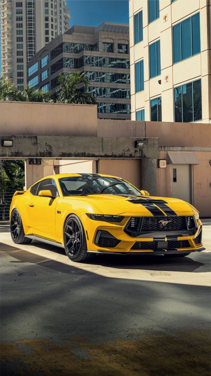 a yellow sports car parked in front of some tall buildings