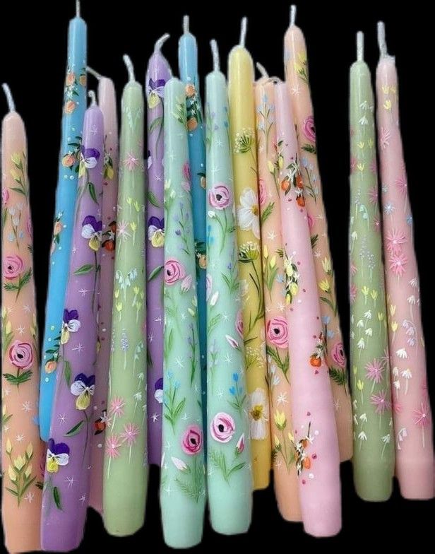 many different colored candles with flowers on them