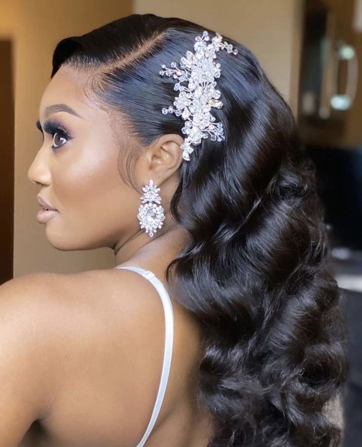 a woman with long black hair wearing a white dress and some flowers in her hair