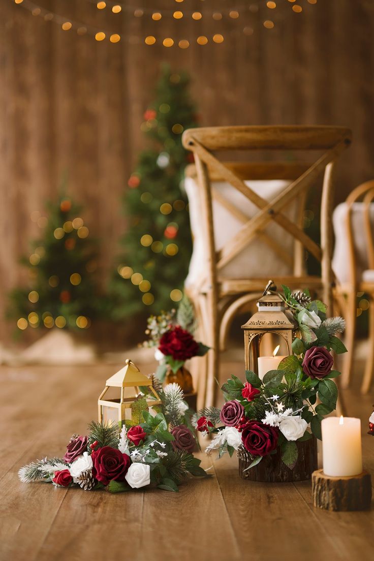 flowers and candles sit on the floor in front of a wooden chair with christmas lights