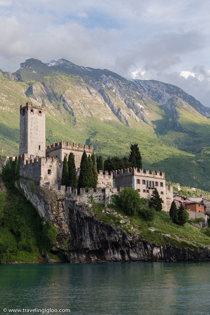 an old castle sitting on the side of a mountain