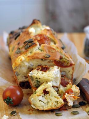 a close up of food on a cutting board with tomatoes and other foods around it