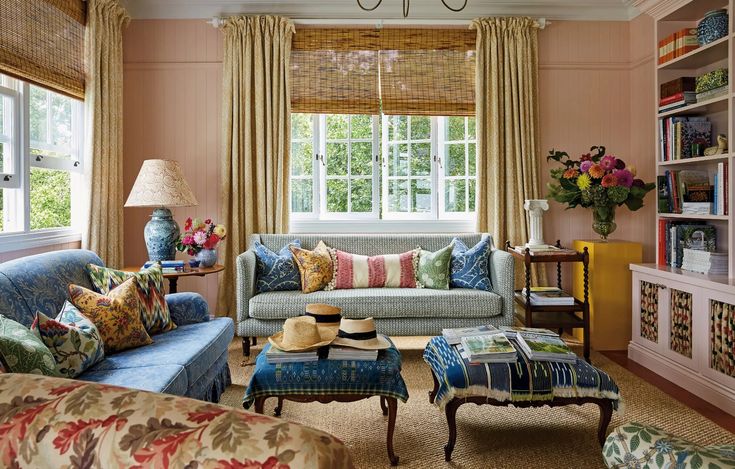 a living room filled with furniture and lots of windows covered in shades of blue, green, pink and yellow