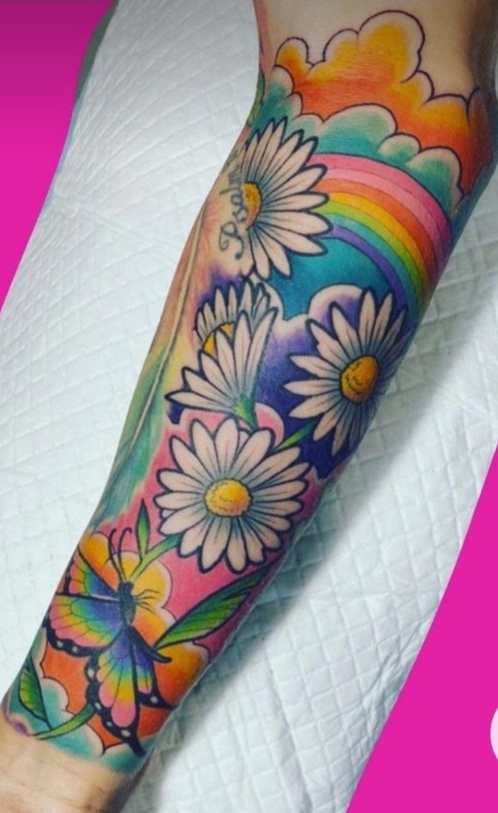 a colorful tattoo with daisies on the arm