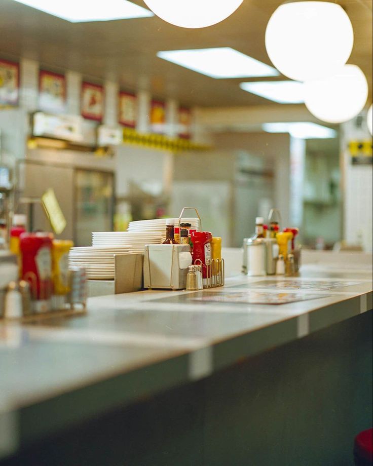 some food is sitting on the counter in a fast food restaurant with lights above it