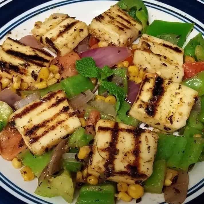 a white plate topped with tofu and vegetables