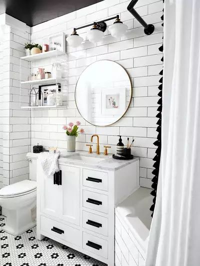 a white bathroom with black and white tile