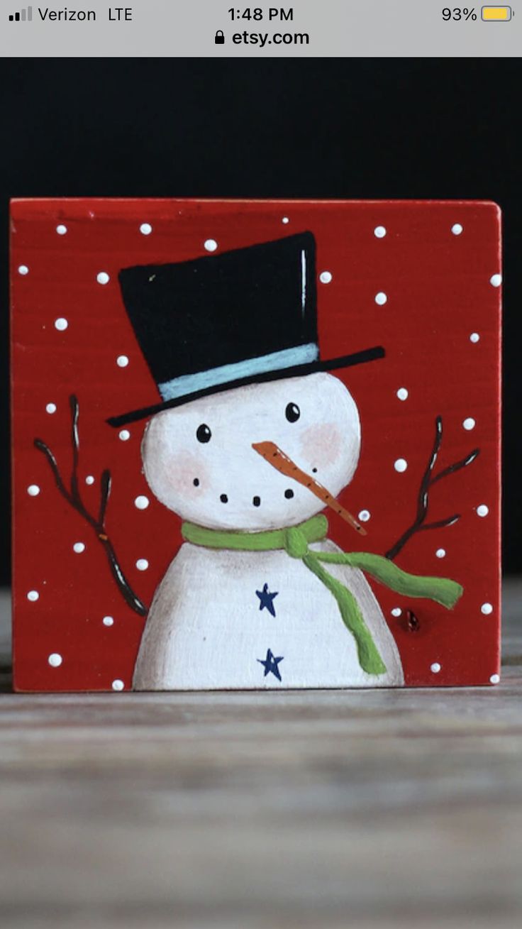 a small wooden block with a snowman painted on it's face and nose