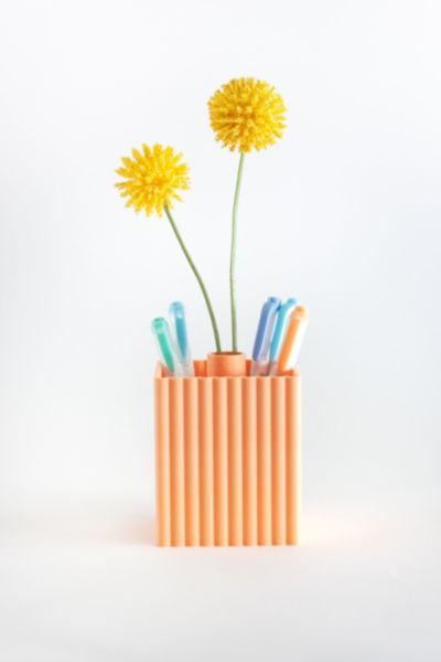 two yellow dandelions are in a pencil holder