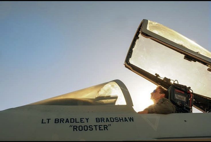 a man sitting in the cockpit of a fighter jet with his camera attached to it