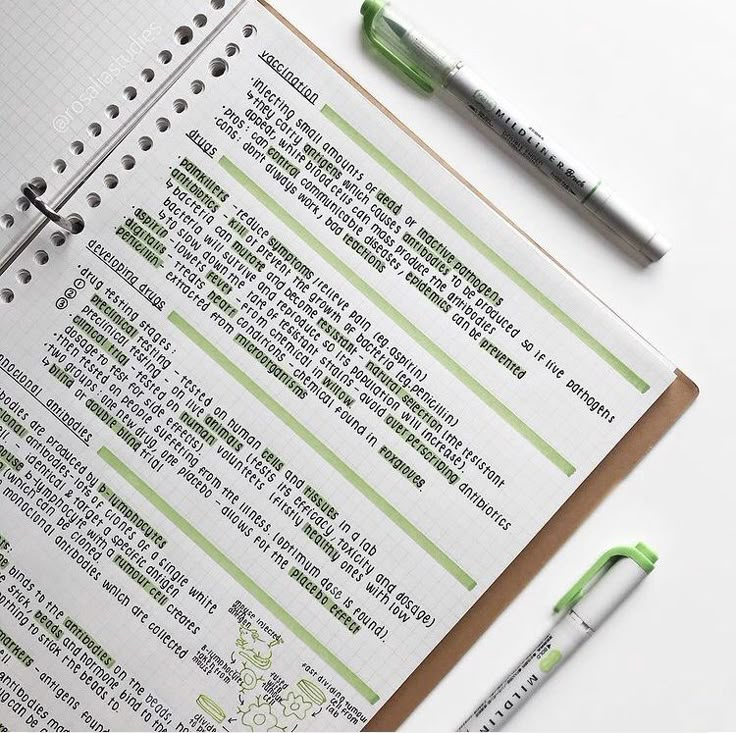 a notepad and pen sitting on top of an open spiral bound notebook next to a green marker