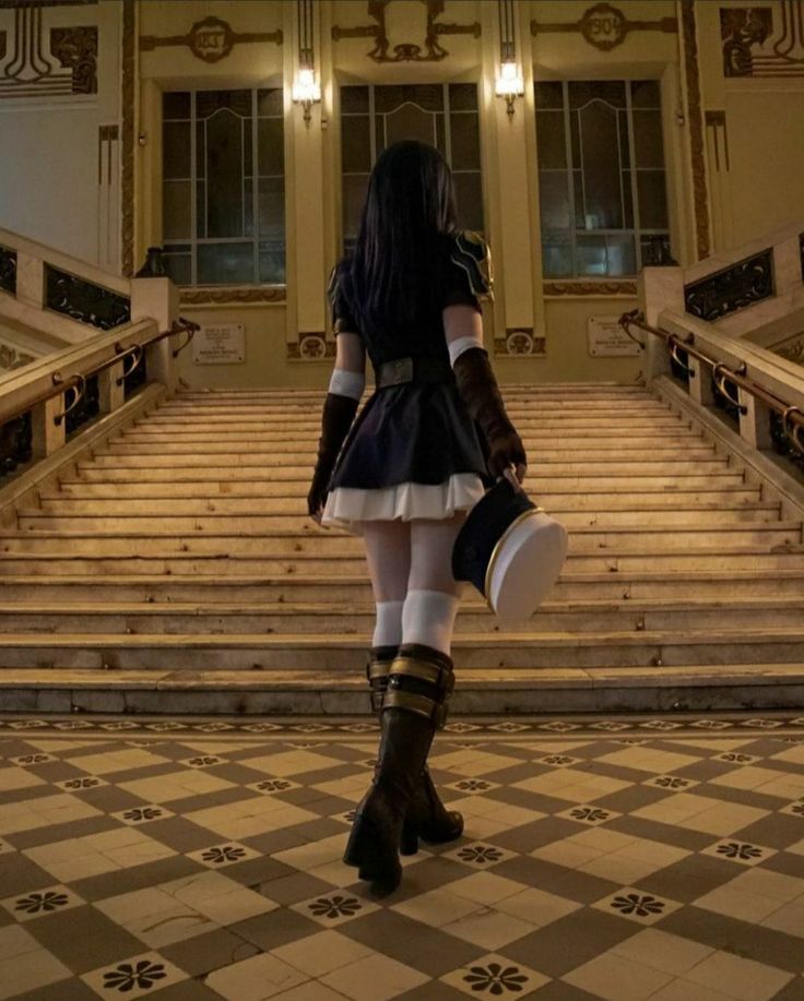 a woman dressed in black and white is walking down the stairs